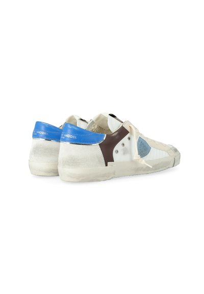 Sneaker bianchi a basso profilo, usurate, con linguetta blu sul tallone, dettaglio laterale marrone, lacci bianchi e suole in gomma rovinate, viste da dietro e di lato.