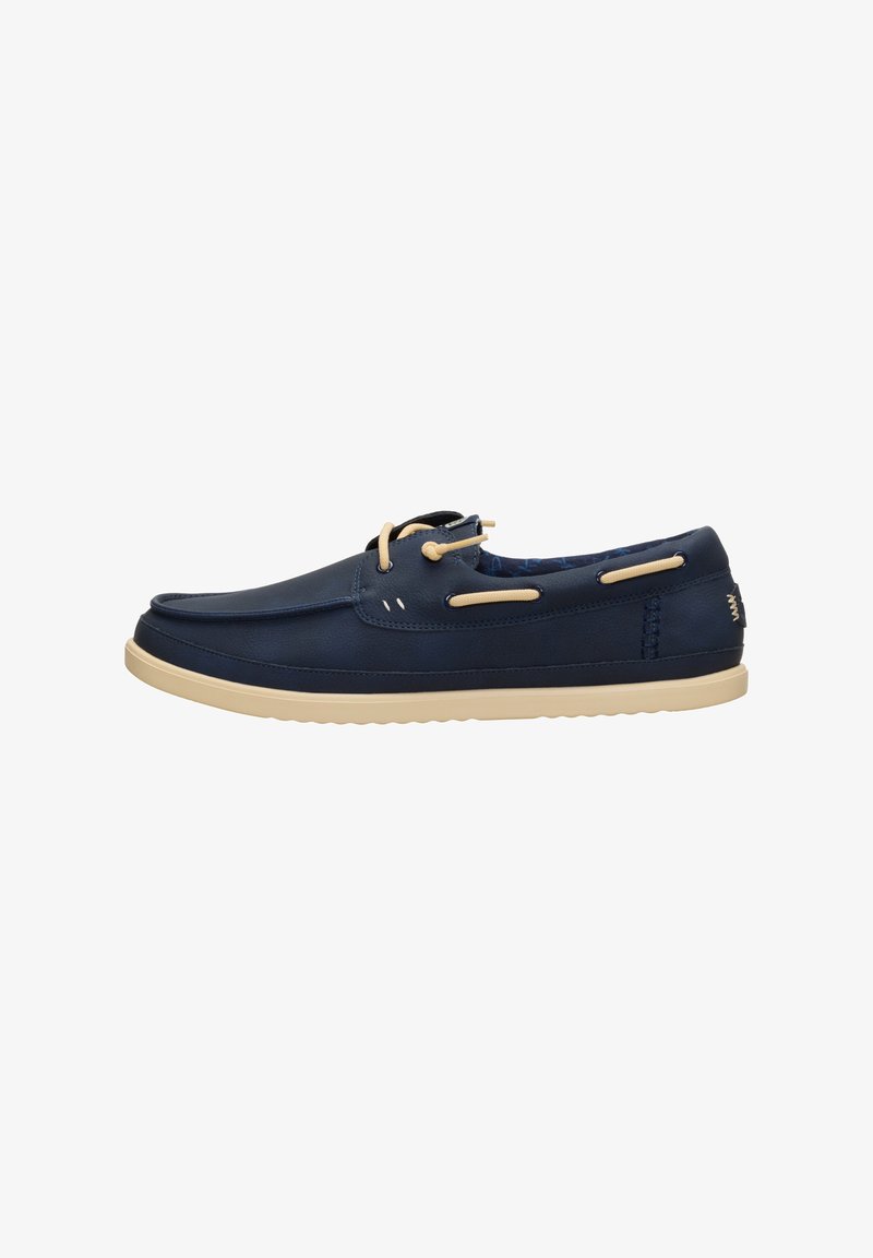 Chaussure bateau en cuir bleu marine avec lacets et semelle beiges, coutures apparentes et doublure intérieure à motif.
