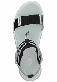 Sandalo con cinturino in nylon nero regolabile, dettagli in metallo argentato, suola bianca e cordino elastico per una calzata sicura. Sole piatto.
