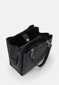 Czarna torebka skórzana o fakturze, z srebrnymi łańcuszkami jako uchwytami, wewnętrzną kieszenią na zamek oraz logo Emporio Armani z przodu.