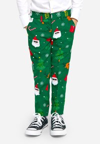 Zaļas svētku bikses ar Ziemassvētku vectētiņa sejām, Ziemassvētku eglītēm un sniegpārsliņām. Kokvilnas audums ar rotaļīgu rakstu, apvienots ar melniem sporta apaviem.