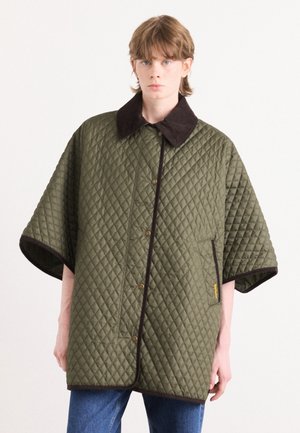 Gequilted buitenkleding in olijfgroen met een bruine kraag, met een knopenfront en grote mouwen, gepresenteerd op een model.