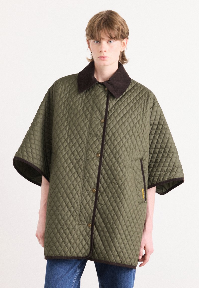 Gequilted buitenkleding in olijfgroen met een bruine kraag, met een knopenfront en grote mouwen, gepresenteerd op een model.