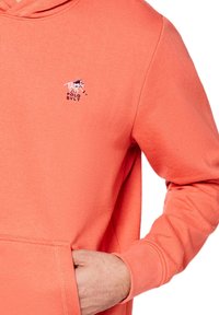 Korale bluza z kapturem ze sznurkiem, z małym haftowanym logo konia i kieszenią z przodu. Wykonana z miękkiej bawełnianej tkaniny.