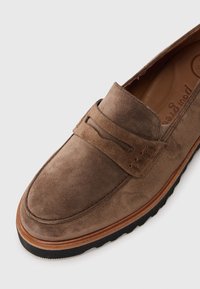 Brune semskede loafers med rund tå, syet detaljer og gummisål. Skoen har en glat tekstur og et minimalistisk design.