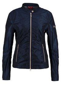 Navy blue quilted jacket with a stand collar, two zippered front pockets, and a central zipper. Made of glossy, lightweight fabric.