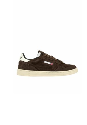 Lage bruine suède sneaker met beige zool, veters aan de voorkant en klein Amerikaans vlagdetail op het zijpaneel.