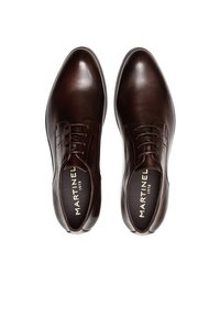 Zapatos de vestir de cuero marrón con un acabado pulido, punteras redondeadas, diseño de cordones y detalles del logo interior en un color contrastante.