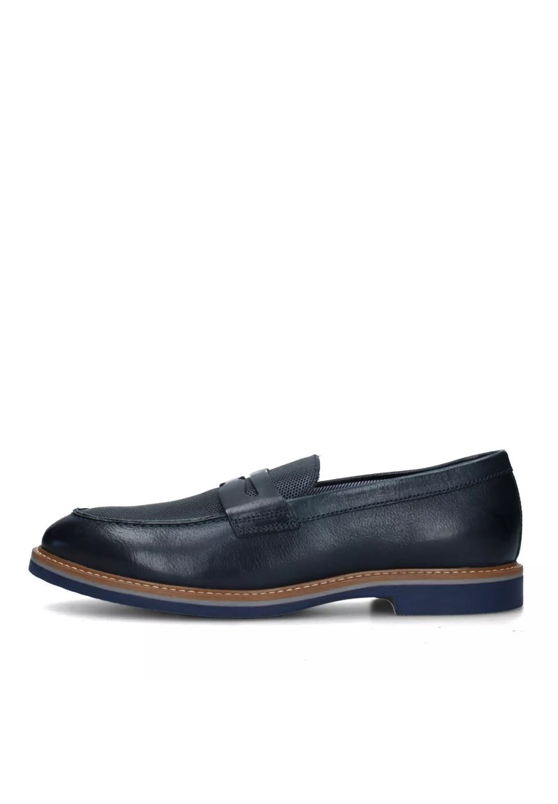Mocassino in pelle blu navy con una texture liscia, dotato di una fascia strutturata sulla parte superiore e una suola tan a contrasto con accenti blu.