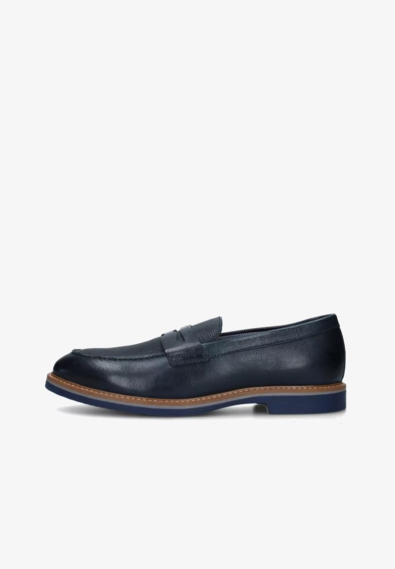 Mocassino in pelle blu navy con una texture liscia, dotato di una fascia strutturata sulla parte superiore e una suola tan a contrasto con accenti blu.