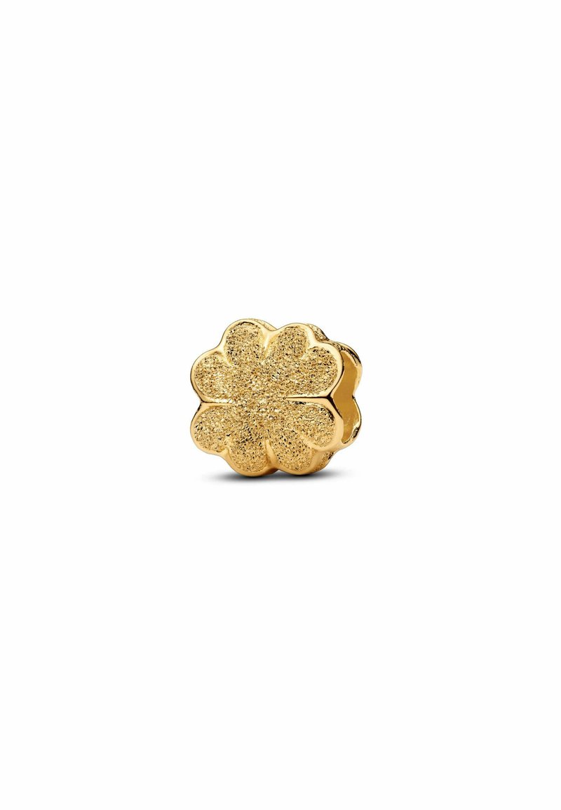 Charm a forma di fiore in oro con superficie testurizzata, caratterizzato da sei petali e una fascia liscia. La luce si riflette sulla sua finitura luccicante.