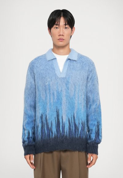 Pull flou en dégradé de bleu avec col, présentant un bleu clair en haut et un bleu foncé à l'ourlet. Coupe ample et aspect texturé.