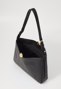 Borsa a tracolla nera in pelle con una texture liscia, design curvo, accessori in tono oro e tracolla regolabile. L'interno presenta una tasca con cerniera.