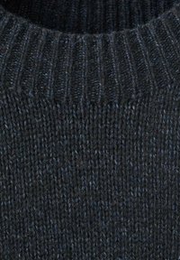 Black knitted sweater fabric with a ribbed design. The texture is soft, featuring a slightly heathered look with dark blue undertones.