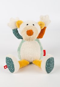 Teddy bear-style plush toy featuring a cream body, orange nose, and multicolored textured arms. Pants in teal with white speckles.