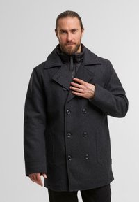 Peacoat nero in misto lana con bottoni doppi, colletto ampio, tasche laterali e uno strato interno trapuntato per l'isolamento.