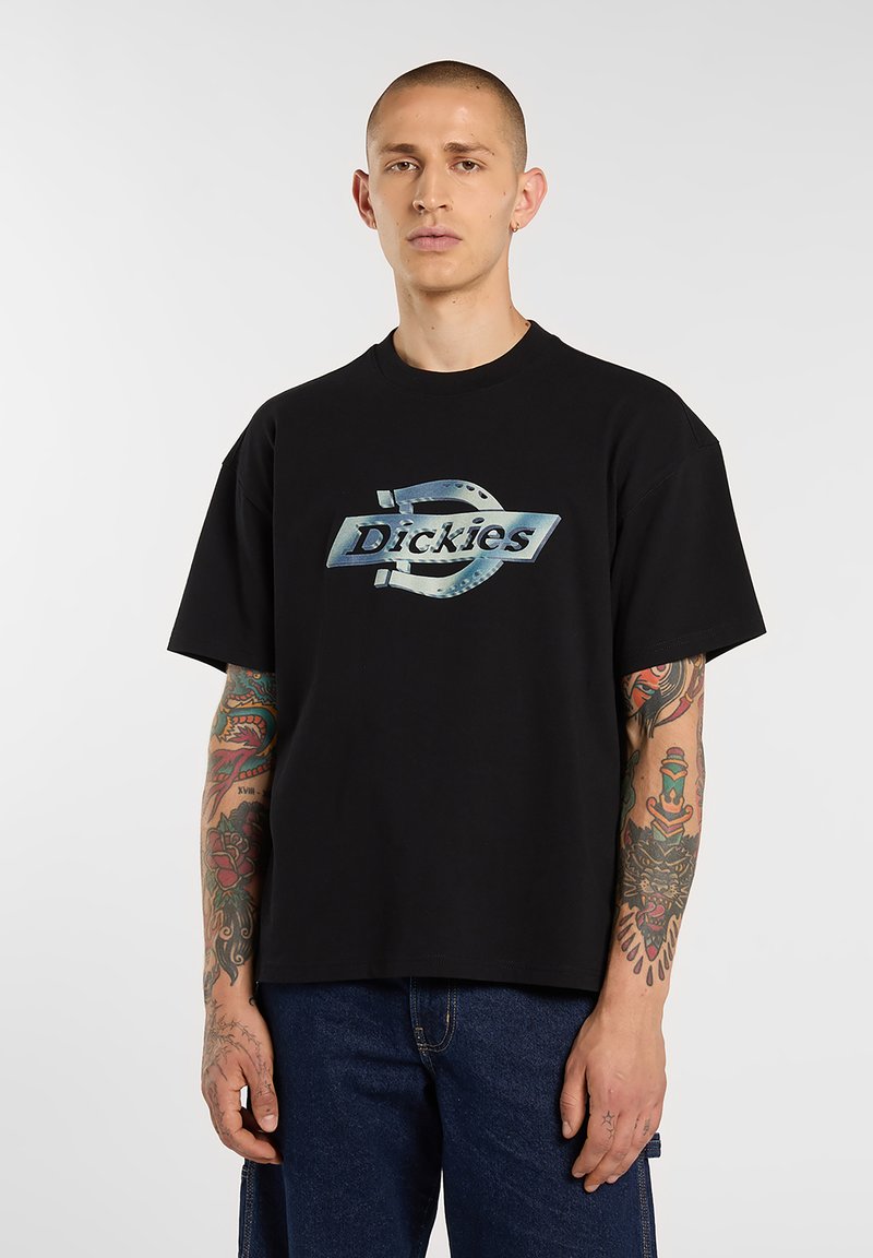 Black cotton T-shirt with a large, metallic blue logo reading "Dickies." Features a relaxed fit and short sleeves.