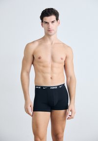 Schwarze Boxershorts mit eng anliegendem Schnitt, ausgestattet mit einem weißen Nike-Logo am Bund, glattem Stoff und einem maßgeschneiderten Design für Komfort.