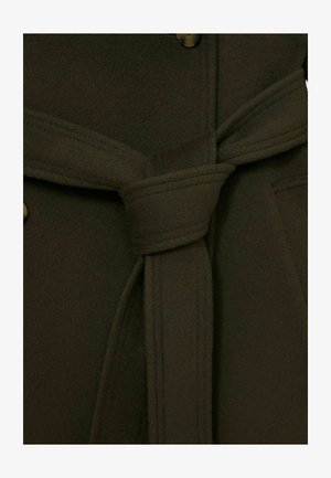 Olijfgroene wollen coat close-up, met een gestrikte tailleband, grote knopen en zachte, textuurvolle stof. Zichtbare stikdetails.