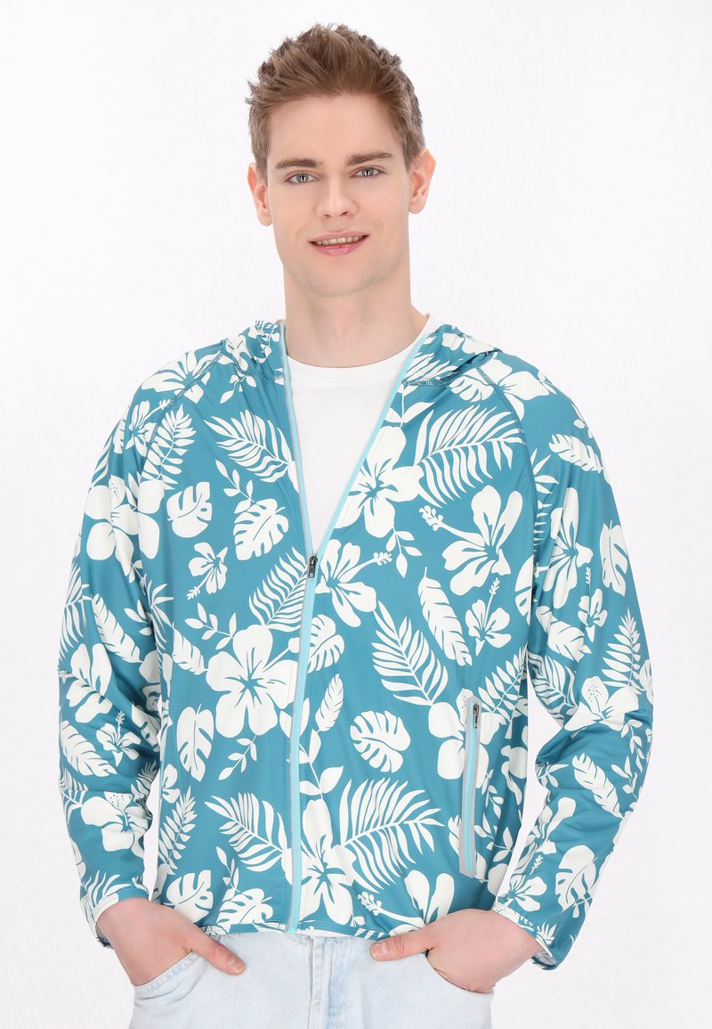 Huvtröja i teal med vita blommor och bladmönster. Utvecklad med dragkedja, långa ärmar och ett lätt, strukturerat tyg.