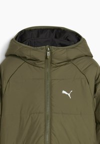 Veste matelassée vert olive avec capuche et fermeture éclair à l'avant, arborant un logo Puma blanc sur le côté gauche de la poitrine.