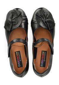 Zapatos Mary Jane de cuero negro con punta redonda, hebilla lateral y un acento floral texturizado en la parte delantera. El interior cuenta con una plantilla color marrón claro.