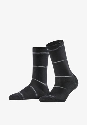 Calzini neri con strisce orizzontali bianche irregolari tie-dye, mostrati in posizione verticale su sfondo bianco.