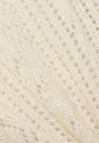 Zarter, cremefarbener Strickstoff mit einem Spitzenmuster, das dezente metallische Fäden für zusätzliche Textur und Dimension aufweist. Leichte und luftige Optik.