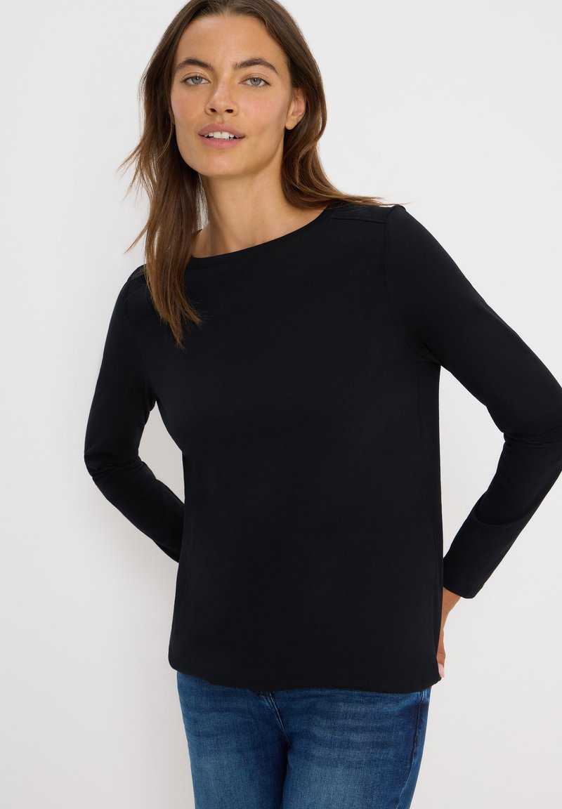 Zwarte lange mouwen shirt met een ronde hals en een gladde textuur, met een rechte snit en minimale ontwerpdetails, gecombineerd met blauwe jeans.