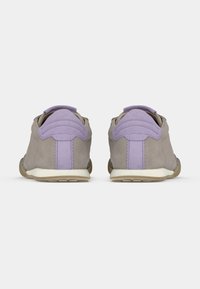 Γκρι πάνινα παπούτσια από σουέντ με λεβαντίνι λεπτομέρειες, υφασμάτινα πάνελ με υφή και λευκή μέση σόλα. Ο σχεδιασμός διαθέτει επικαλυπτόμενες ραφές και πίσω ταινία για τράβηγμα.