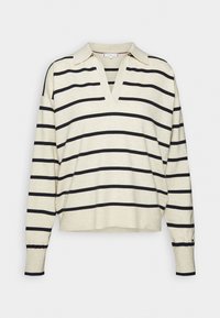 Pull en maille crème à manches longues avec large col en V, rayures horizontales noires et poignets ajustés.