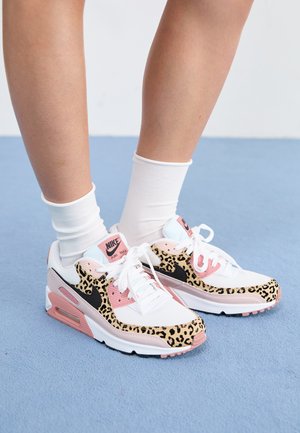 Nike Air Max tenisice imaju bijele i ružičaste tonove s leopard uzorak naglascima, mrežastim i kožnim materijalima, te izraženom gumenom potplatom.