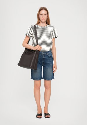 T-shirt en coton rayé, shorts en denim bleu, sac en cuir noir avec finition texturée et sandales plates noires. Tenue simple et décontractée.