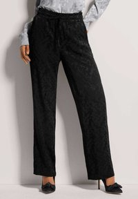 Zwarte wijde broek met een subtiel ton-sur-ton camouflagepatroon, met een elastische tailleband en een trekkoord. Soepele, lichte stof.