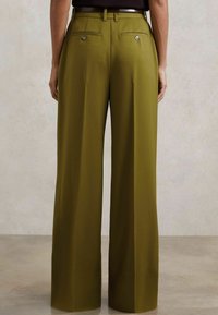 Hlače širokih nogavica u maslinasto zelenoj boji, izrađene od glatke tkanine. Imaju džepove s kopčama na gumb i ravni pojas s petljama za remen.