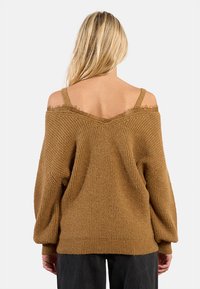 Maglioncino marrone lavorato a maglia con design off-shoulder, tessuto testurizzato, vestibilità oversize e maniche lunghe con un delicato pizzo sul collo.