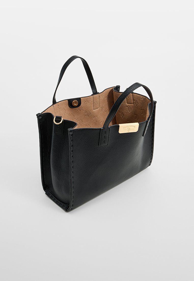Bolso tote de cuero negro con superficie texturizada, parte superior abierta, dos asas cortas y un interior marrón claro. Presenta una placa de logo en tono dorado.