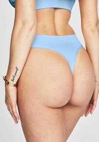 Ljusblå ribbade bikiniunderdel med högskuren design, utrustad med ett smalt midjeband och minimal täckning bakåt, som framhäver en slät textur och sömmar.