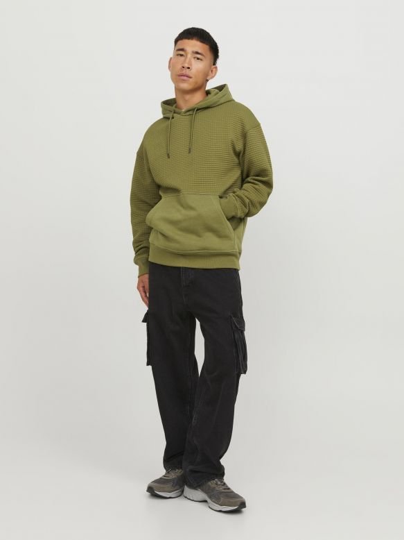 Olive green textured hoodie with a kangaroo pocket and drawstring hood. Paired with black cargo pants and gray sneakers.
