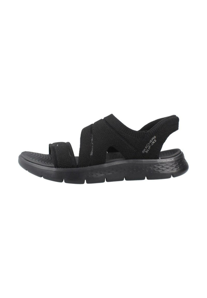 Sandalias negras de slip-on con tiras elásticas, suela acolchada y suela texturizada. Diseño simple, adecuado para el uso casual.