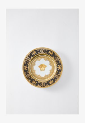 Runder Porzellanteller mit schwarzen und goldenen Akzenten, komplexen Mustern und einem zentralen Motiv eines Gesichts, umgeben von kunstvollen Details.