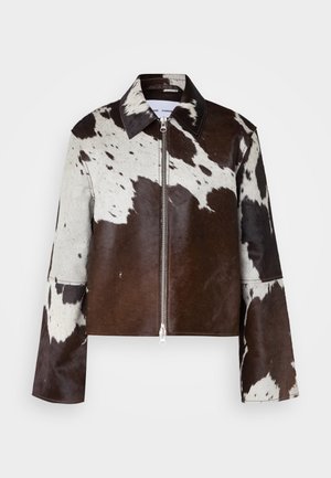 Veste courte en cuir de vache avec un motif patchwork brun et blanc. Comprend un col pointu et une fermeture à glissière à l'avant.