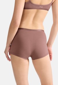 Brune stretch bomuld hipster-shorts med glat tekstur og elastisk talje. Enkelt design uden synlige mønstre eller detaljer.