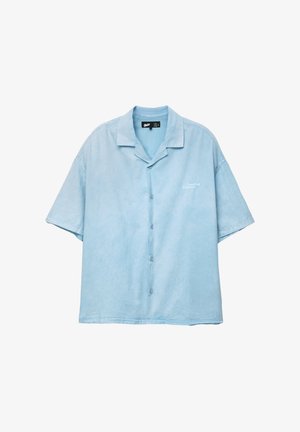 Kurzärmliges Hemd in hellem Blau aus Stoff, mit einem Notch-Kragen und dezentem "Creative Manner"-Stick auf der linken Seite.