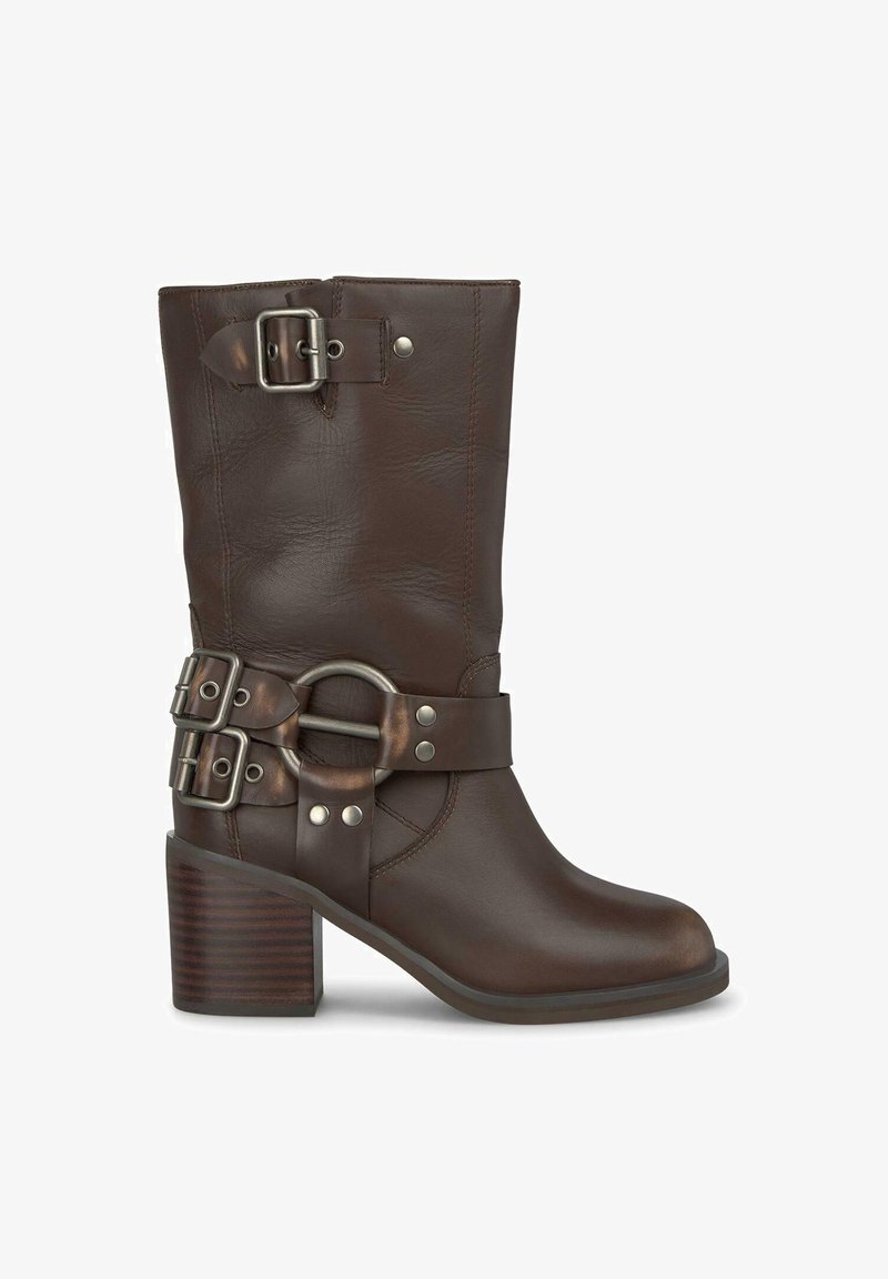 Brązowy skórzany botek za kostkę z grubym obcasem, z szerokim paskiem z podwójnymi klamrami i okrągłym metalowym akcentem. Gładka tekstura, solidny design.