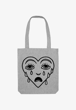 Borsa a tote in tessuto grigia con un design di cuore nero con occhi tristi e lacrime. La forma del cuore è centrale, contornata da linee spesse.