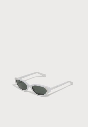 White plastic sunglasses with green lenses, curved cat-eye shape, and decorative rhinestone accents on the frame.