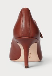 Rjavi usnjeni čevlji z visoko peto in ostrim nosom. Gladka tekstura, eleganten dizajn in vitka stiletto peta. Blagovna znamka vidna znotraj.