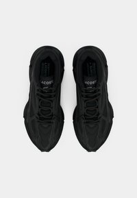 Μαύρα αθλητικά παπούτσια με επίπεδη κορδόνια, κατασκευασμένα από επικαλυμμένο συνθετικό υλικό με υφή. Διαθέτουν διακριτικό λογότυπο της μάρκας στην γλώσσα.