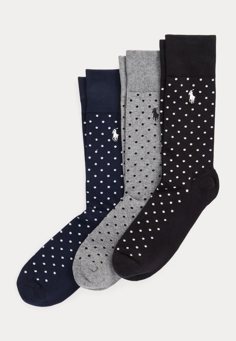Trois paires de longues chaussettes en bleu marine, gris et noir avec des pois blancs et un petit logo brodé sur chaque paire.